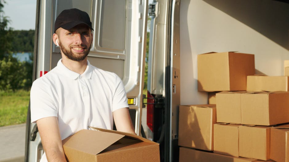 A scene of home relocation with two men from Man with Van Osterley engaged in furniture transport outside a residential property. One man is standing beside the open rear doors of a white van, which i